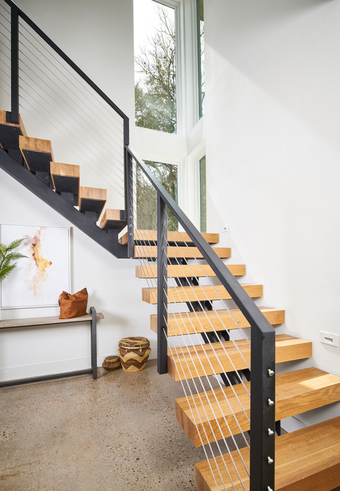Idées déco pour un escalier sans contremarche flottant contemporain avec des marches en bois, un garde-corps en câble et rangements.