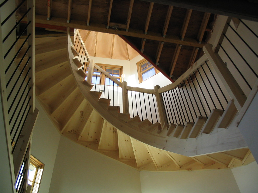 Exempel på en mycket stor rustik svängd trappa i trä, med sättsteg i trä