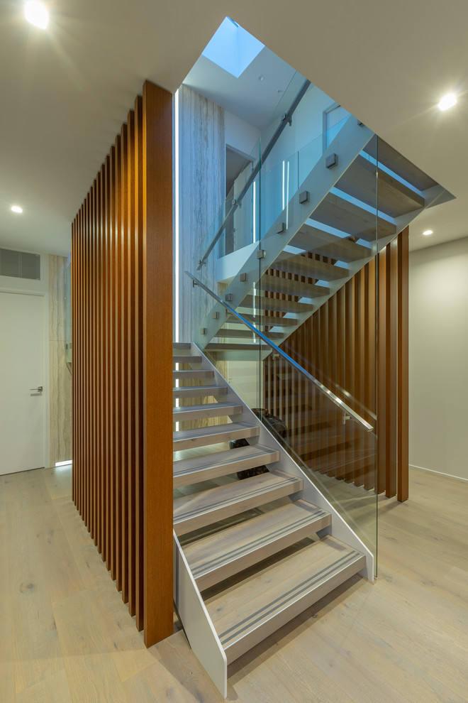 Exemple d'un grand escalier sans contremarche tendance en U avec des marches en bois et un garde-corps en métal.