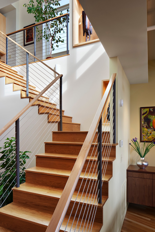 Modelo de escalera contemporánea con escalones de madera, contrahuellas de madera y barandilla de cable