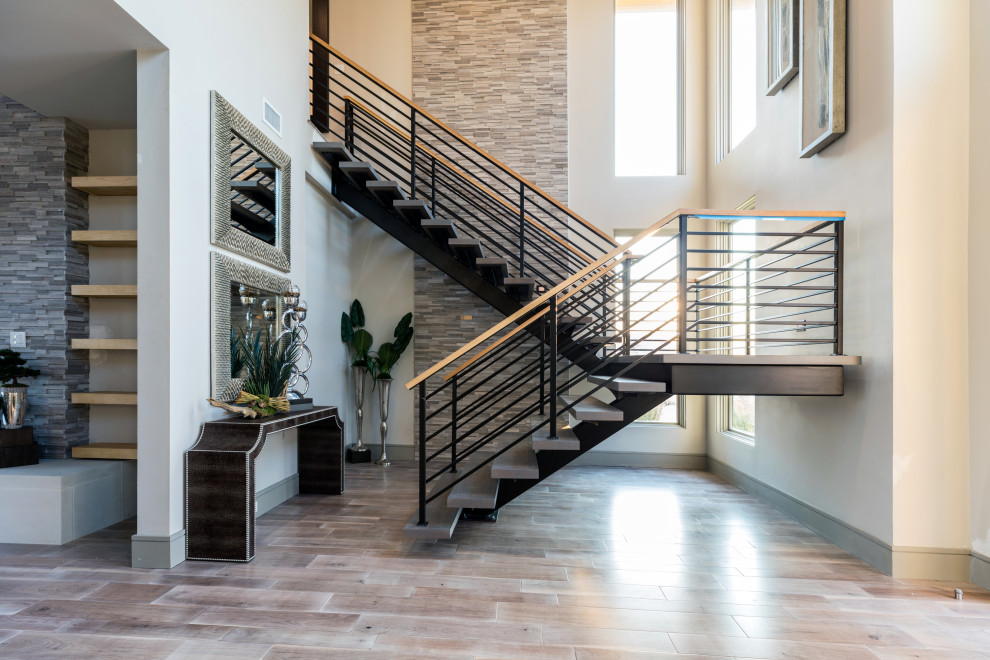 This is an example of a large contemporary concrete u-shaped metal railing staircase in Dallas with open risers.