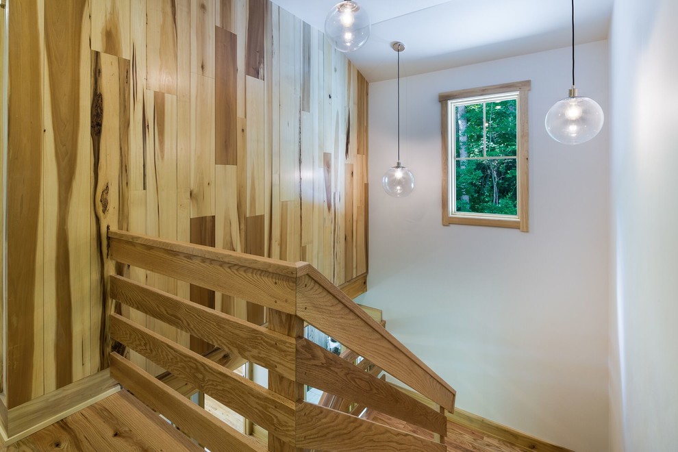 Ejemplo de escalera en U actual de tamaño medio con escalones de madera y contrahuellas de madera