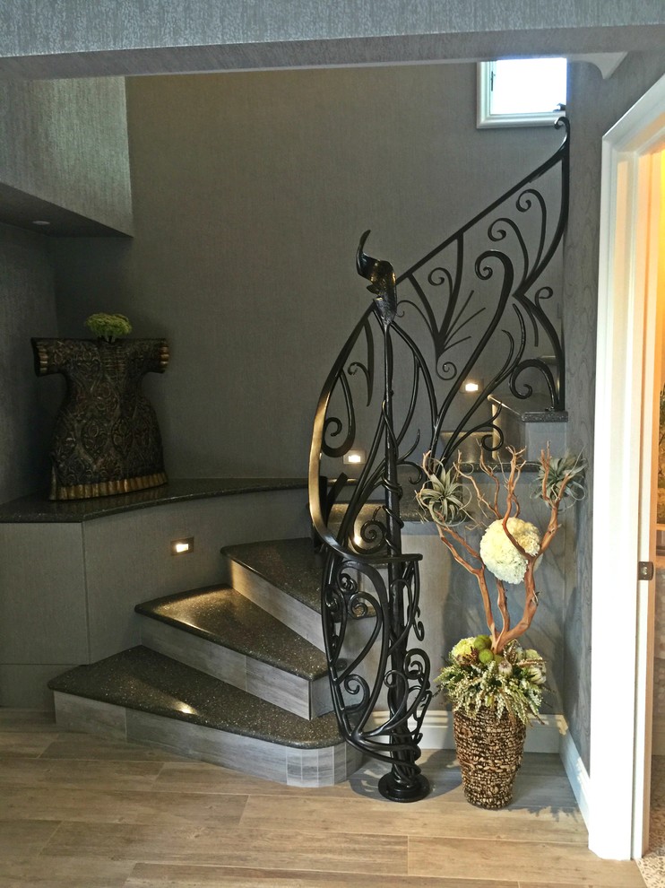Diseño de escalera curva clásica renovada de tamaño medio con contrahuellas con baldosas y/o azulejos y barandilla de metal