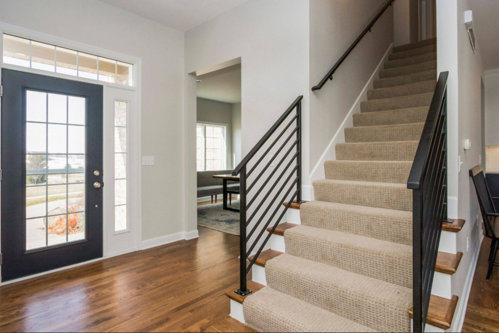 Свежая идея для дизайна: прямая лестница среднего размера в стиле неоклассика (современная классика) с деревянными ступенями, ковровыми подступенками и металлическими перилами - отличное фото интерьера