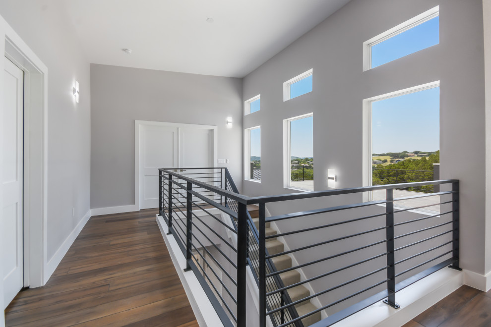 Gerade, Große Moderne Treppe mit Teppich-Treppenstufen, Teppich-Setzstufen und Stahlgeländer in Austin