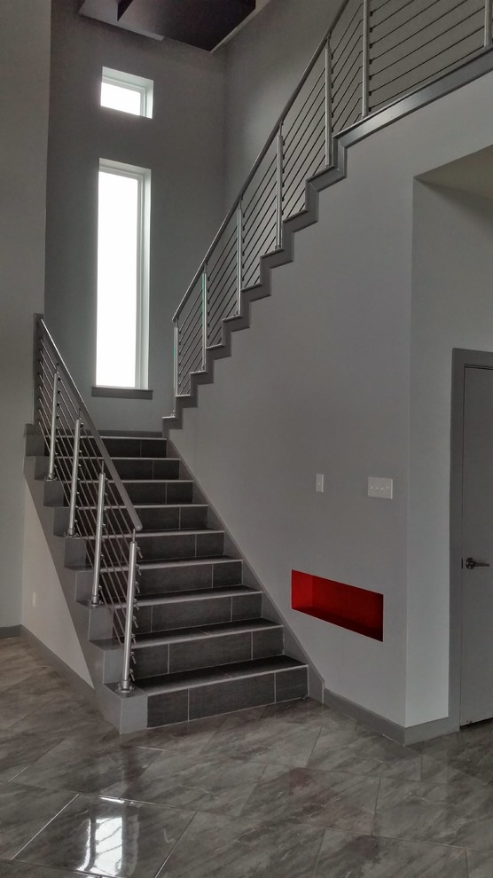 Mittelgroße Moderne Treppe in L-Form mit gefliesten Treppenstufen und gefliesten Setzstufen in Austin