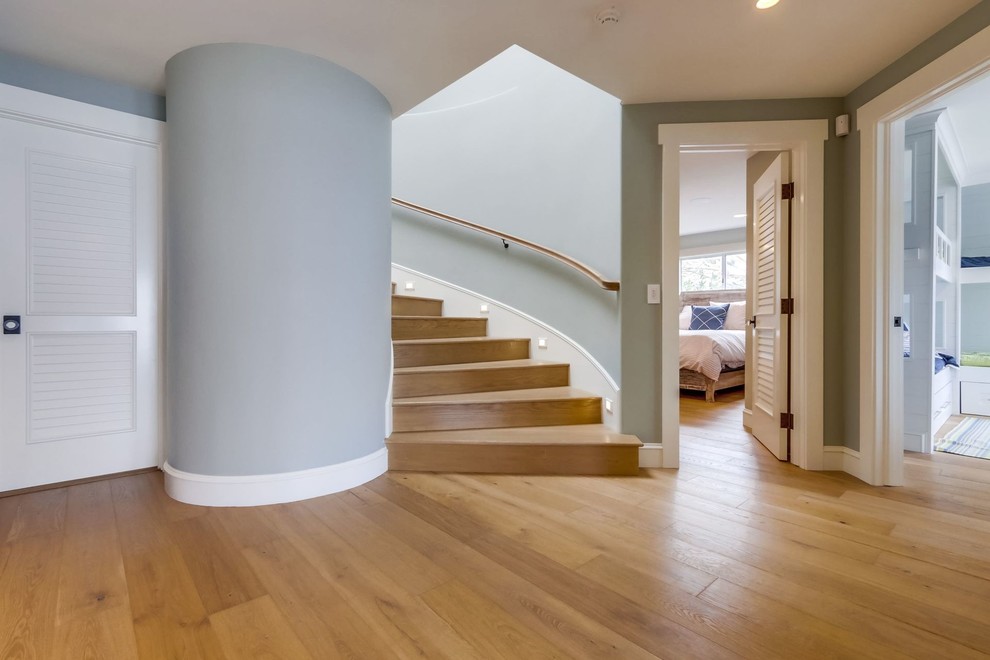 Стильный дизайн: изогнутая деревянная лестница среднего размера в морском стиле с деревянными ступенями и деревянными перилами - последний тренд