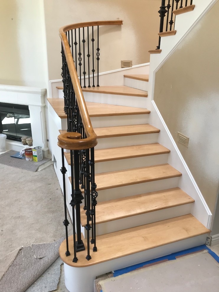 Medium sized traditional wood curved mixed railing staircase in Orange County with travertine risers.