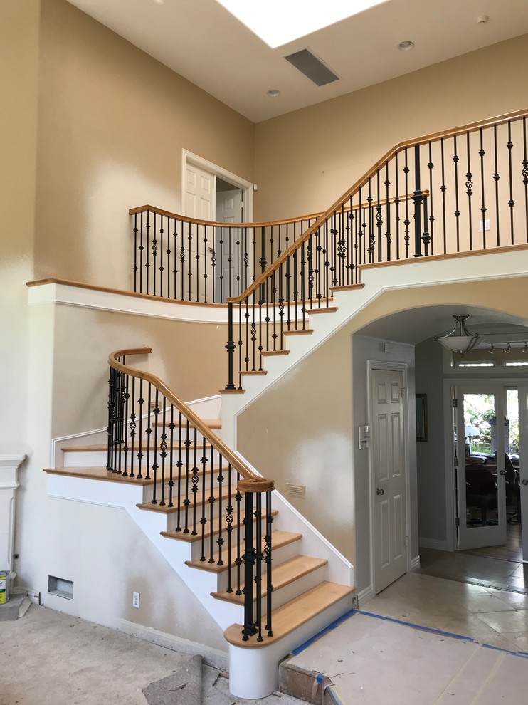 Inspiration for a mid-sized timeless wooden curved mixed material railing staircase remodel in Orange County with travertine risers