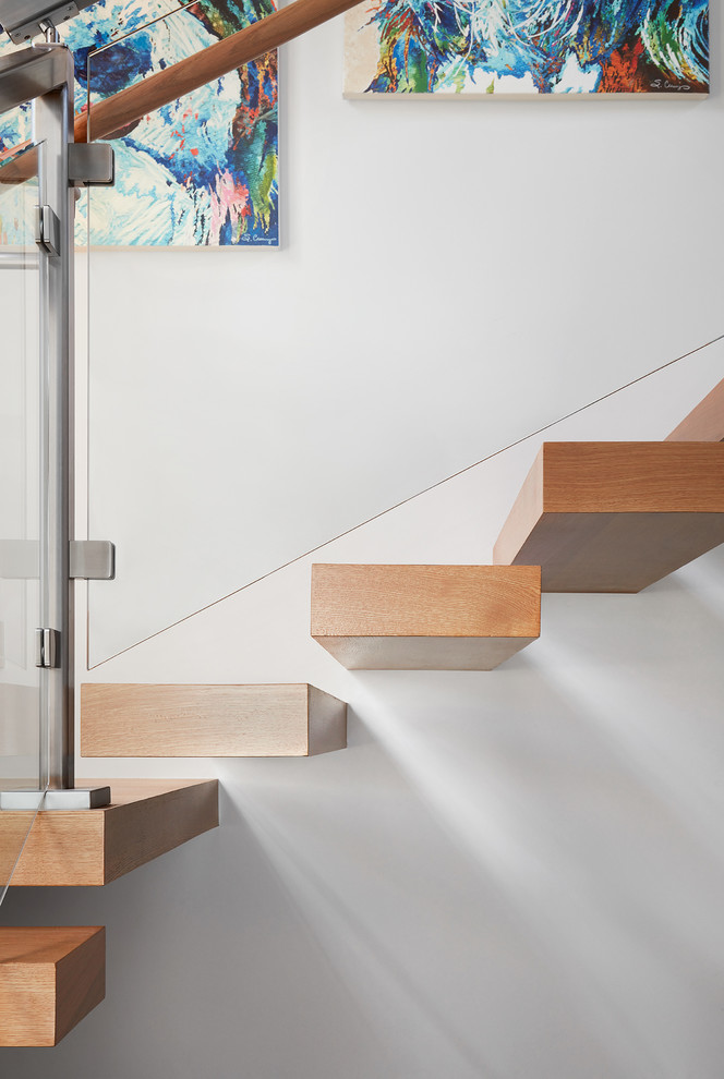 Imagen de escalera suspendida tradicional renovada grande sin contrahuella con escalones de madera y barandilla de vidrio