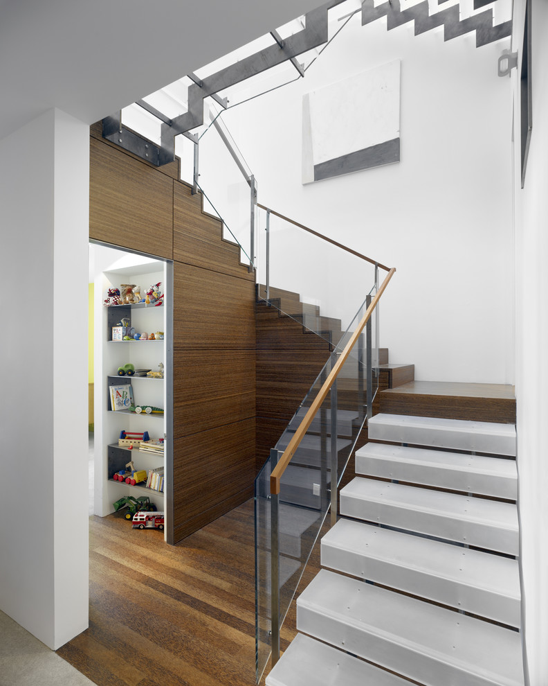Réalisation d'un escalier design avec des marches en bois et un garde-corps en verre.