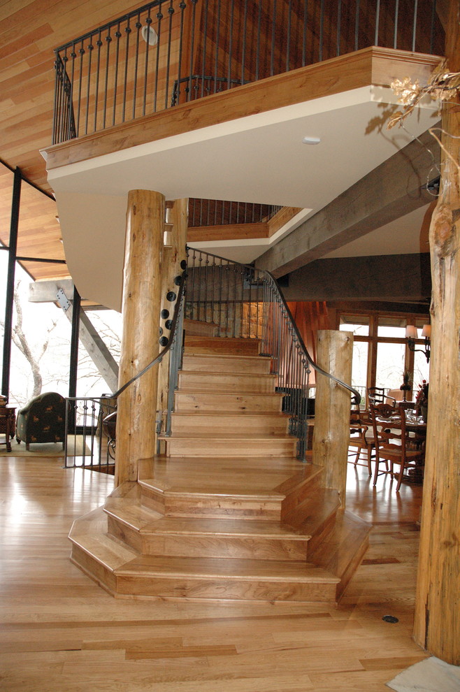Inspiration for a large rustic wooden curved metal railing staircase remodel in Kansas City with wooden risers