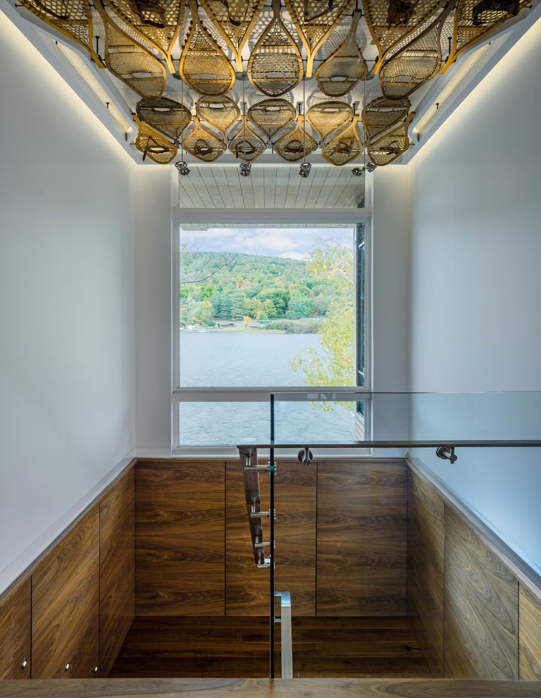 Foto de escalera recta contemporánea de tamaño medio con escalones de madera, barandilla de vidrio y contrahuellas de madera