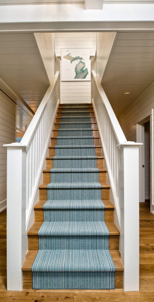 Ejemplo de escalera recta costera grande con escalones de madera y barandilla de madera