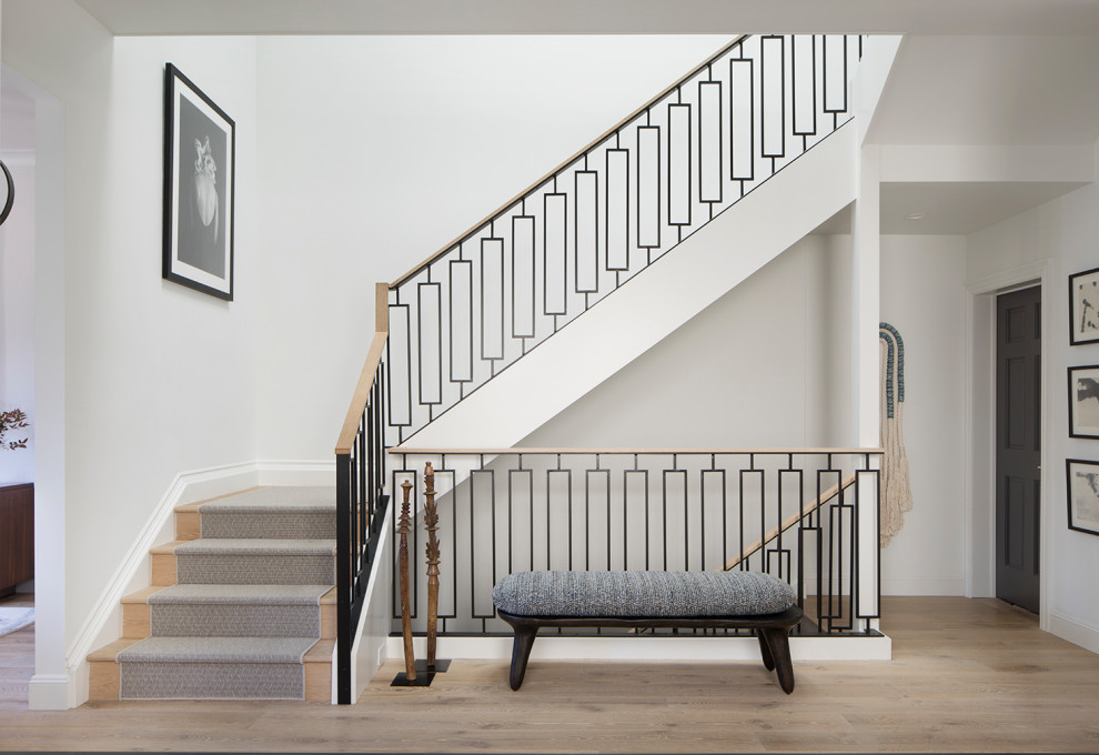 Exempel på en klassisk l-trappa, med heltäckningsmatta, sättsteg med heltäckningsmatta och räcke i flera material
