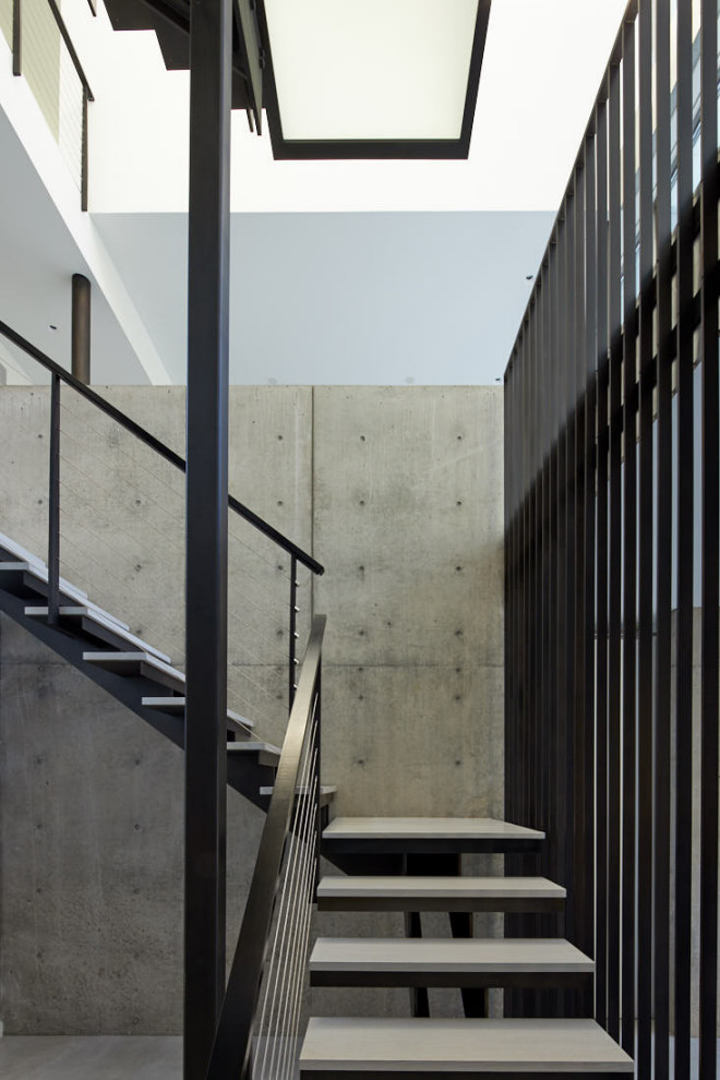 Пример оригинального дизайна: большая угловая металлическая лестница в стиле модернизм с бетонными ступенями и металлическими перилами