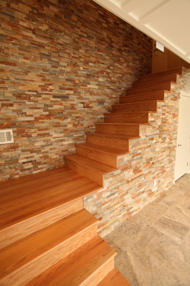 На фото: угловая деревянная лестница в стиле модернизм с деревянными ступенями с