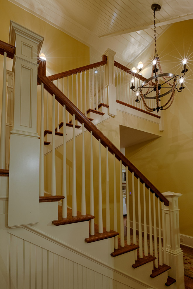 Ejemplo de escalera en U tradicional de tamaño medio con escalones de madera, contrahuellas de madera y barandilla de madera