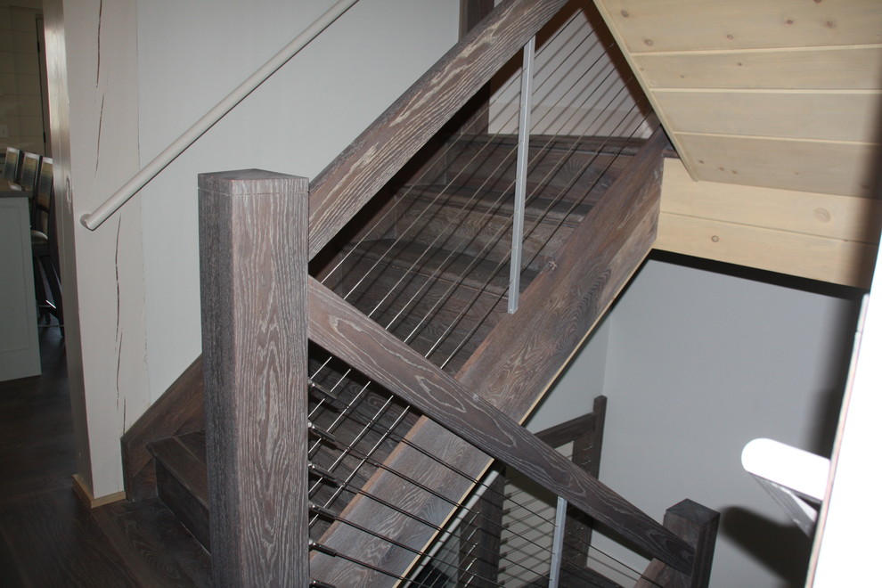 Photo of a medium sized rustic wood u-shaped wood railing staircase in Omaha with wood risers.