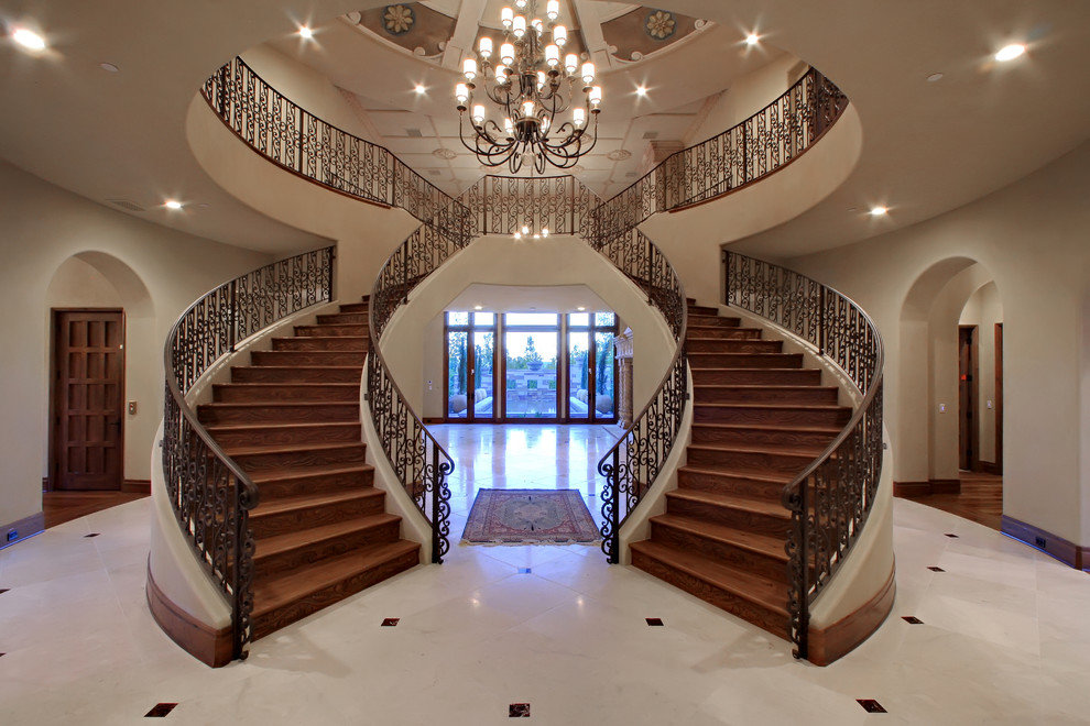 Expansive mediterranean wood u-shaped staircase in Las Vegas with wood risers.