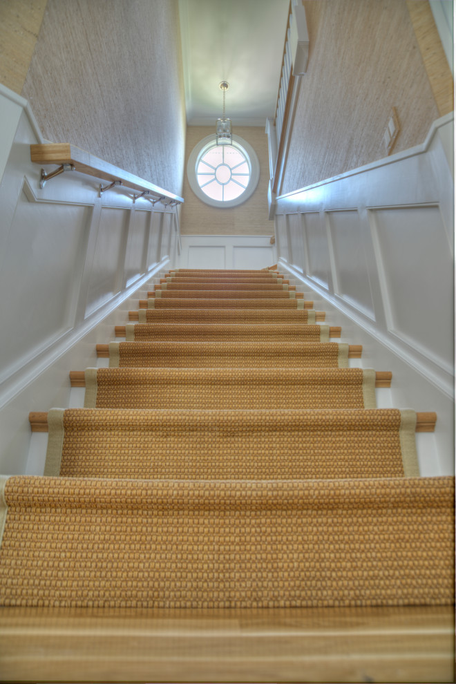 На фото: угловая деревянная лестница среднего размера в стиле кантри с деревянными ступенями, деревянными перилами и панелями на части стены