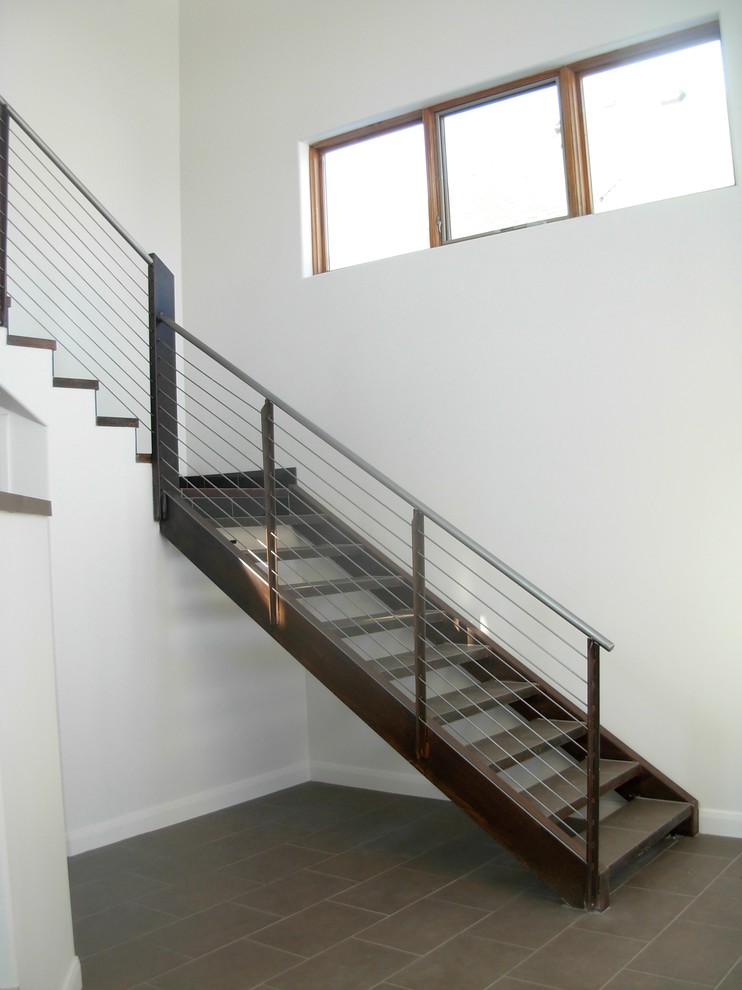 Exempel på en mellanstor modern l-trappa, med öppna sättsteg, räcke i metall och klinker