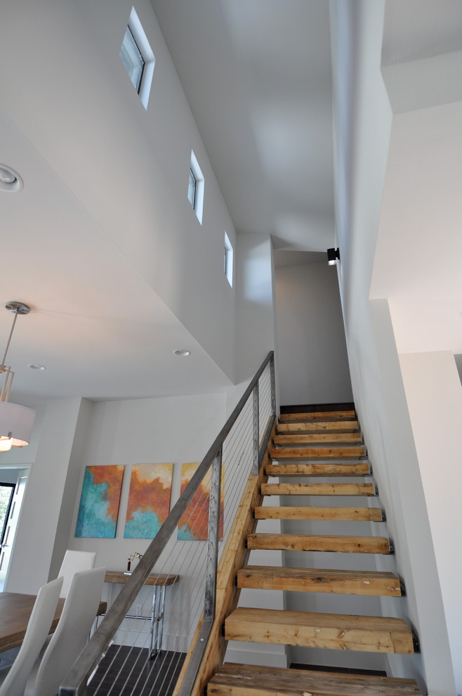 Photo of a large contemporary wood floating staircase in Austin with open risers.