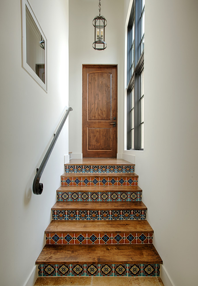 Cette photo montre un escalier droit méditerranéen avec des marches en bois, des contremarches carrelées et un garde-corps en métal.