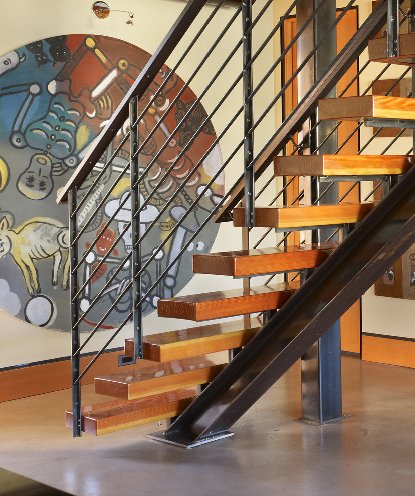 シアトルにあるラグジュアリーな小さなインダストリアルスタイルのおしゃれな直階段 (木の蹴込み板、金属の手すり) の写真