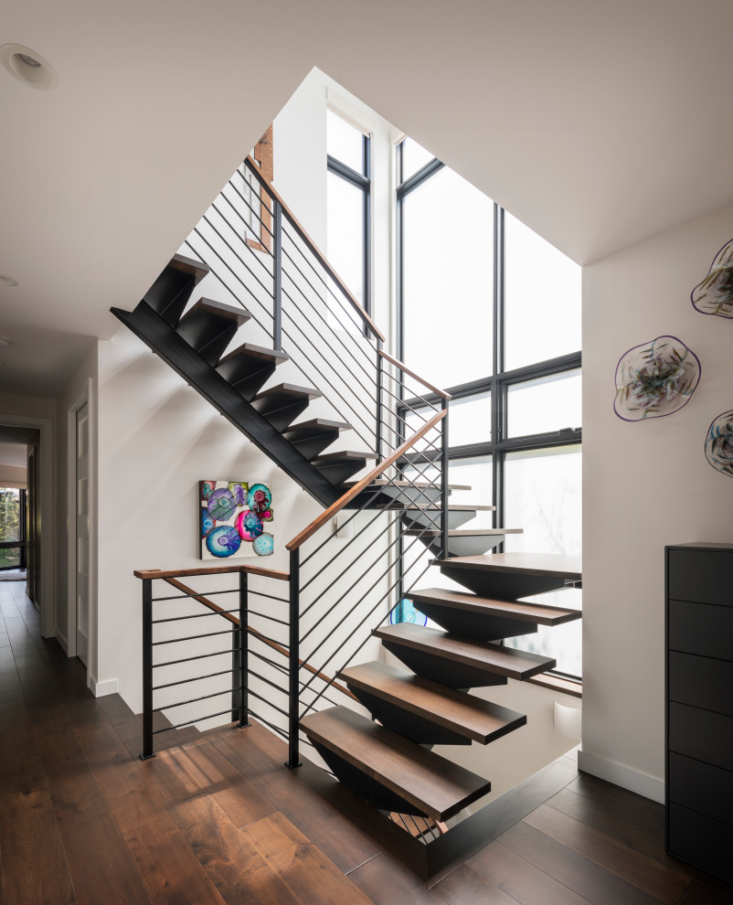 Idées déco pour un escalier flottant contemporain avec des marches en bois et un garde-corps en câble.