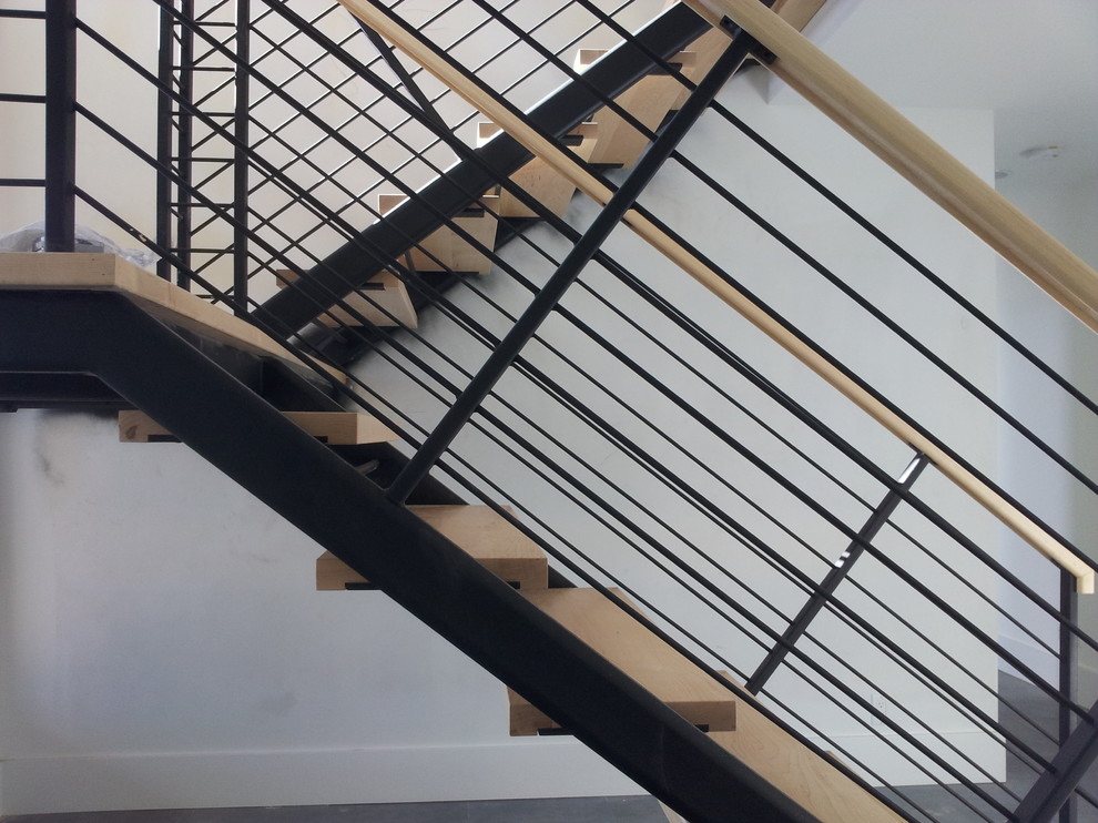 Idée de décoration pour un grand escalier sans contremarche design en U avec des marches en bois.