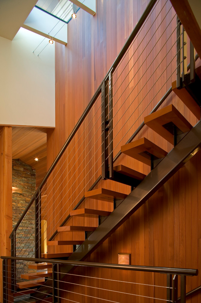 Ejemplo de escalera recta contemporánea de tamaño medio sin contrahuella con escalones de madera y barandilla de metal