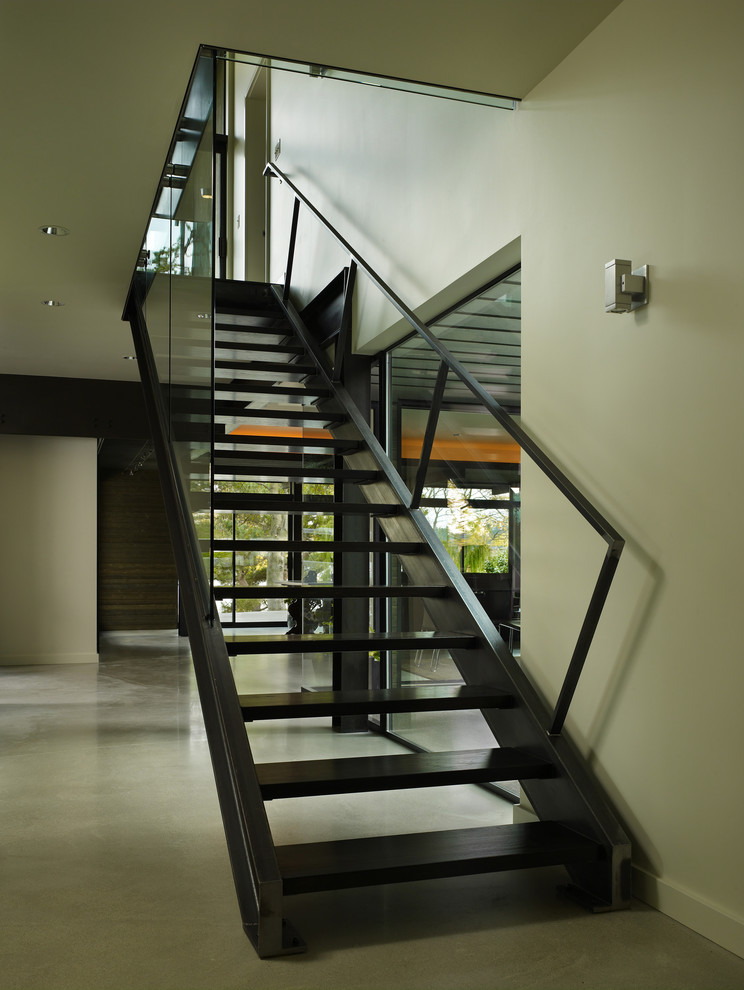 Idée de décoration pour un escalier sans contremarche minimaliste avec un garde-corps en verre.
