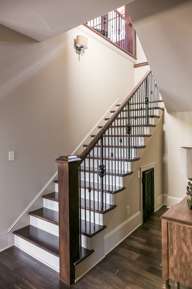 Cette image montre un grand escalier peint chalet en U avec des marches en bois et éclairage.
