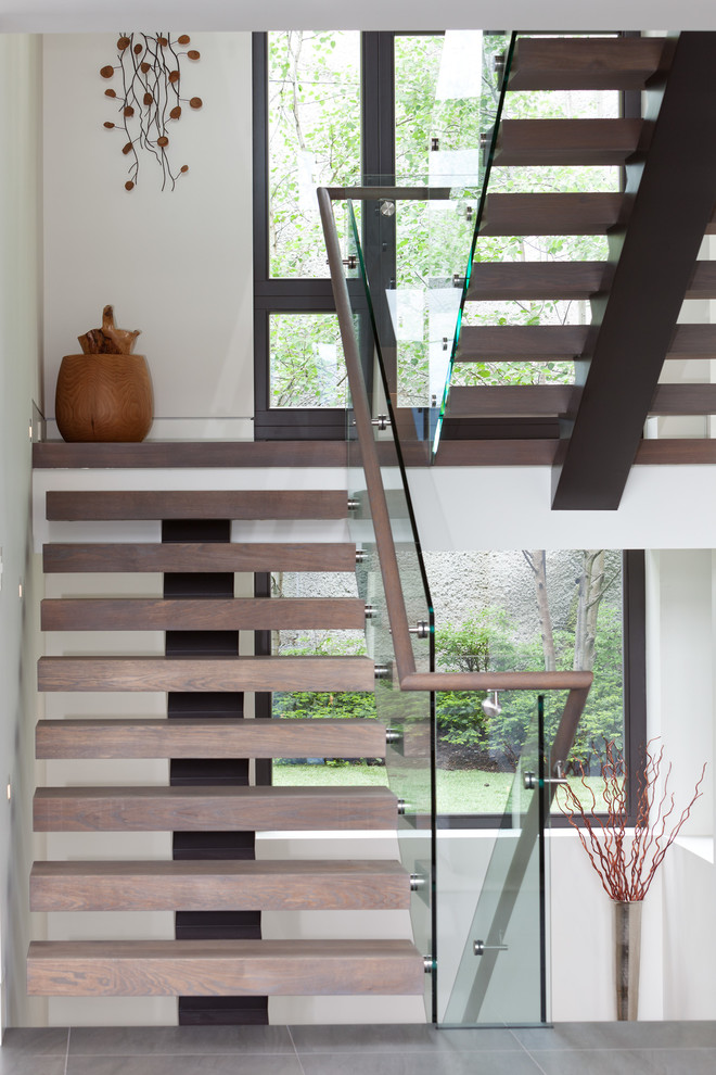 Свежая идея для дизайна: лестница на больцах в современном стиле с деревянными ступенями и стеклянными перилами без подступенок - отличное фото интерьера
