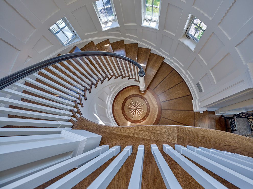 Aménagement d'un escalier peint courbe classique de taille moyenne avec des marches en bois et un garde-corps en bois.