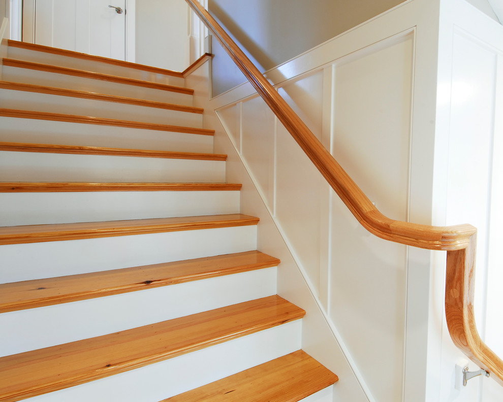 Ejemplo de escalera en L de estilo americano de tamaño medio con escalones de madera y contrahuellas de madera pintada
