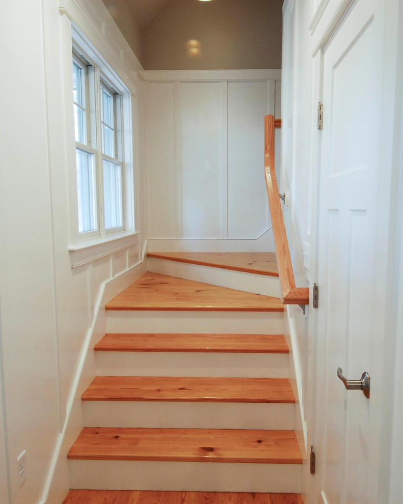 Ejemplo de escalera en L de estilo americano de tamaño medio con escalones de madera, contrahuellas de madera pintada y barandilla de madera