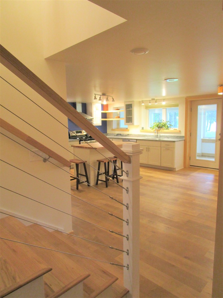 Photo of a medium sized classic wood straight metal railing staircase in Portland Maine with wood risers.