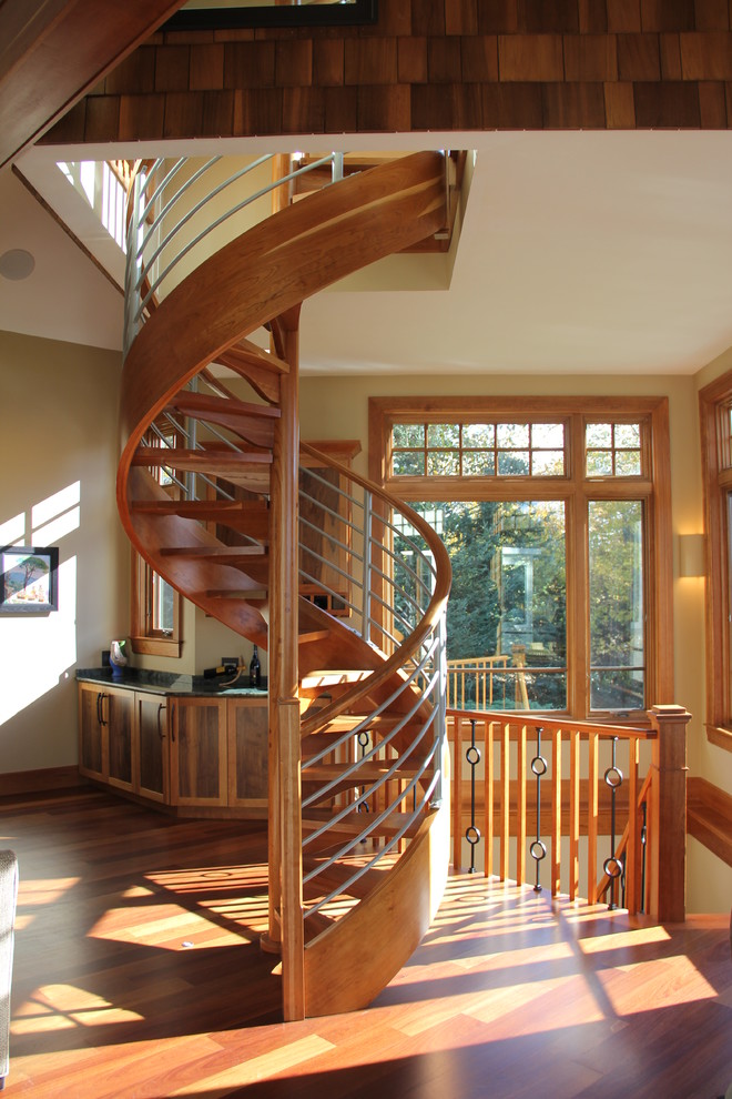 Пример оригинального дизайна: огромная винтовая лестница в стиле неоклассика (современная классика) с деревянными ступенями и перилами из смешанных материалов без подступенок