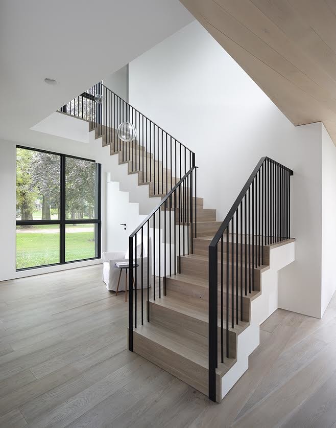 Ejemplo de escalera en L minimalista de tamaño medio con escalones de madera, contrahuellas de madera y barandilla de metal