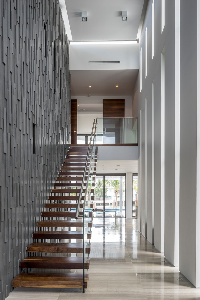 Идея дизайна: большая прямая лестница в стиле модернизм с деревянными ступенями и стеклянными перилами без подступенок
