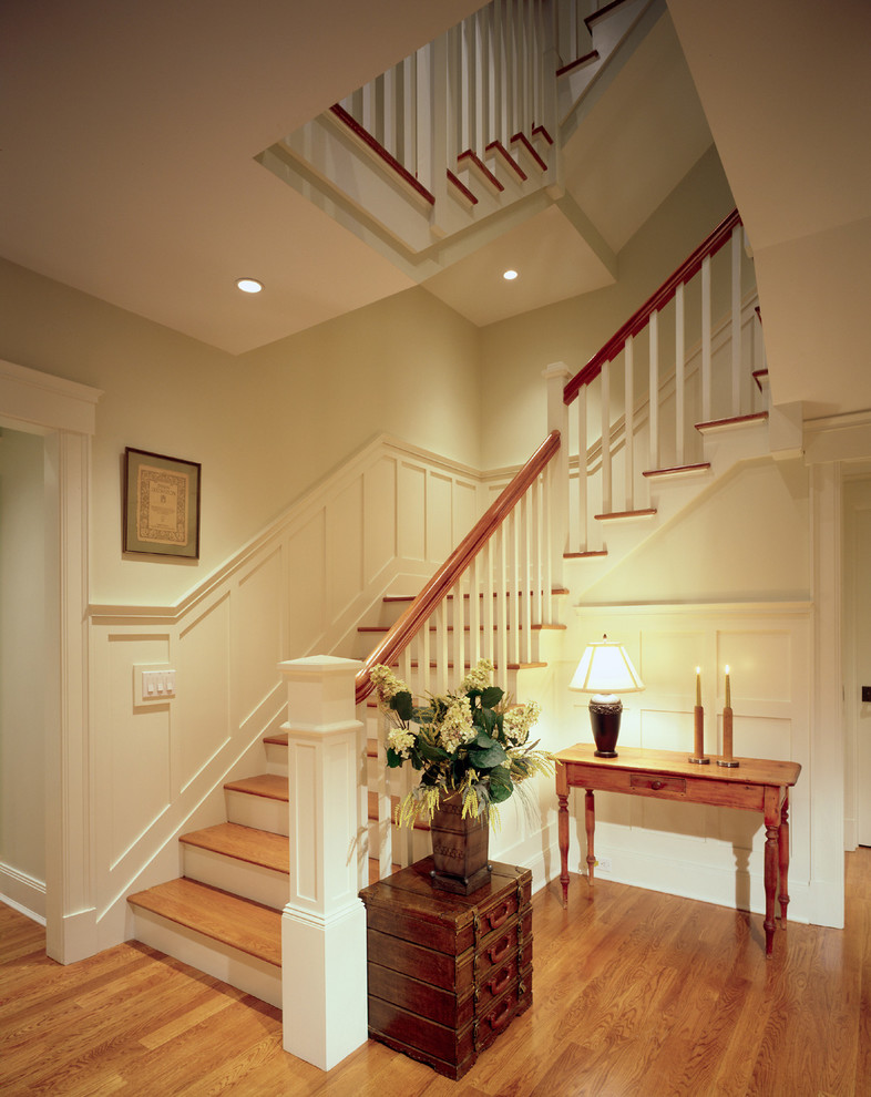 Ejemplo de escalera de caracol clásica de tamaño medio con escalones de madera y contrahuellas de madera pintada