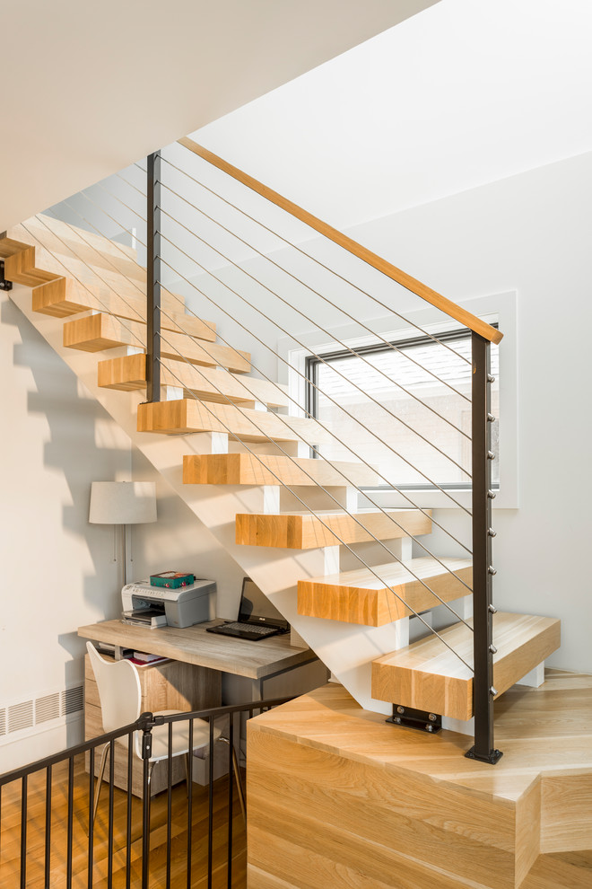 Esempio di una scala a rampa dritta minimalista di medie dimensioni con pedata in legno, nessuna alzata e parapetto in cavi