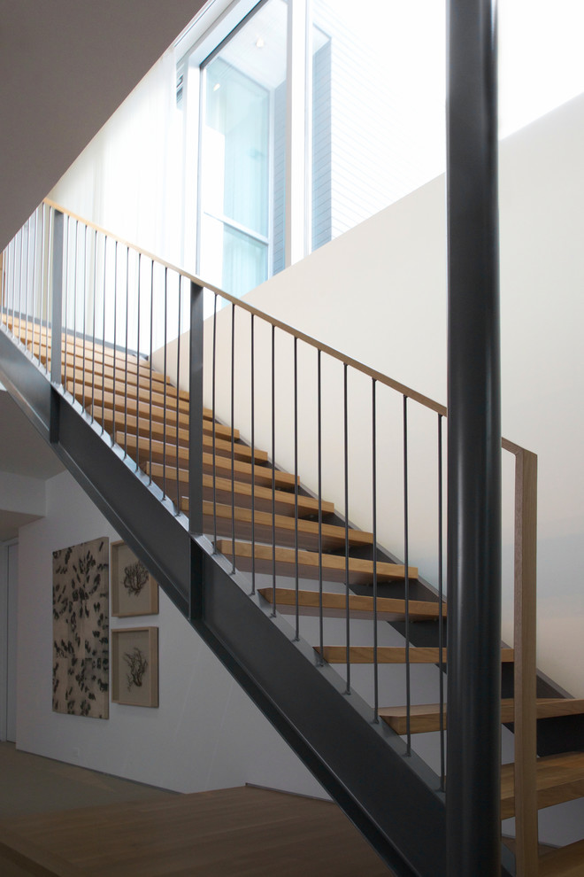 Aménagement d'un escalier droit contemporain avec des marches en bois et des contremarches en métal.