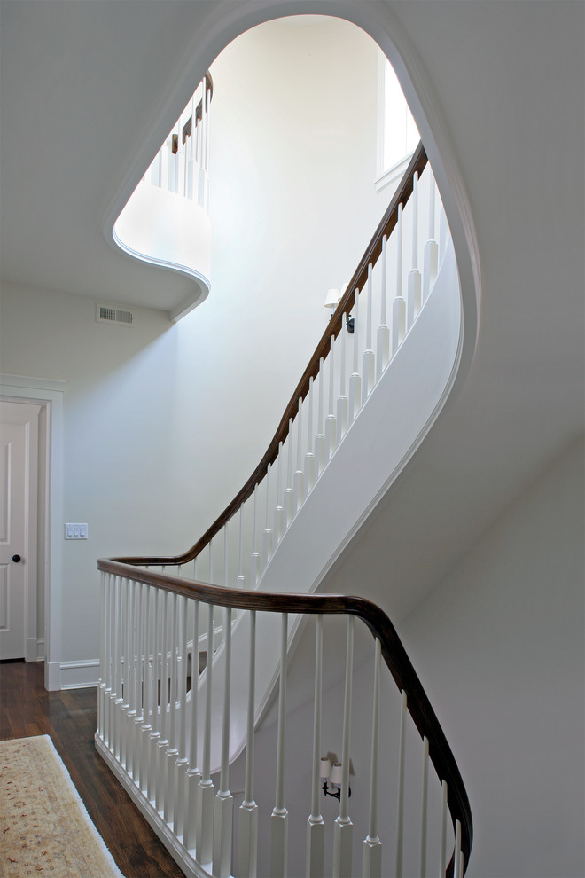 Staircase - huge traditional wooden curved staircase idea in Chicago with painted risers
