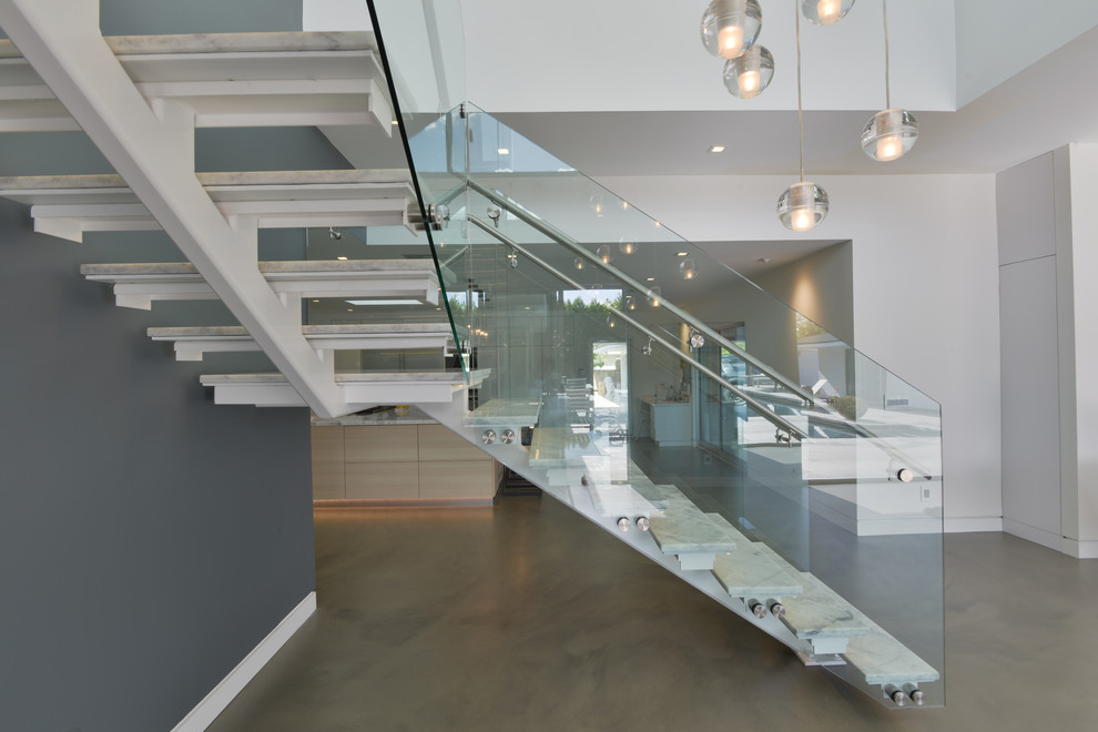 Inspiration pour un escalier sans contremarche minimaliste en L et marbre de taille moyenne avec un garde-corps en verre.