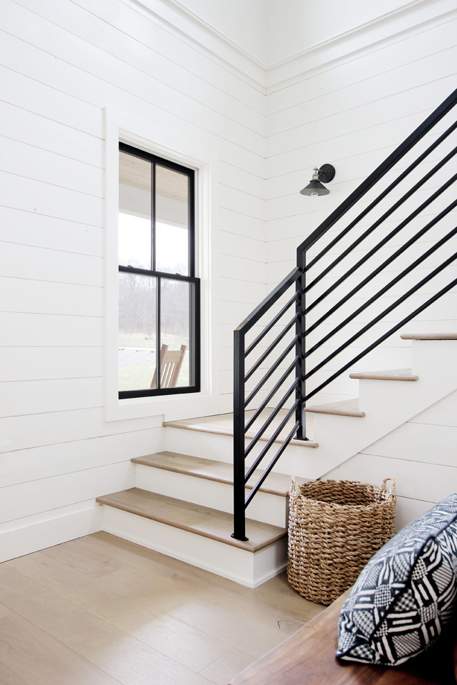 Imagen de escalera en L campestre con escalones de madera, contrahuellas de madera y barandilla de metal