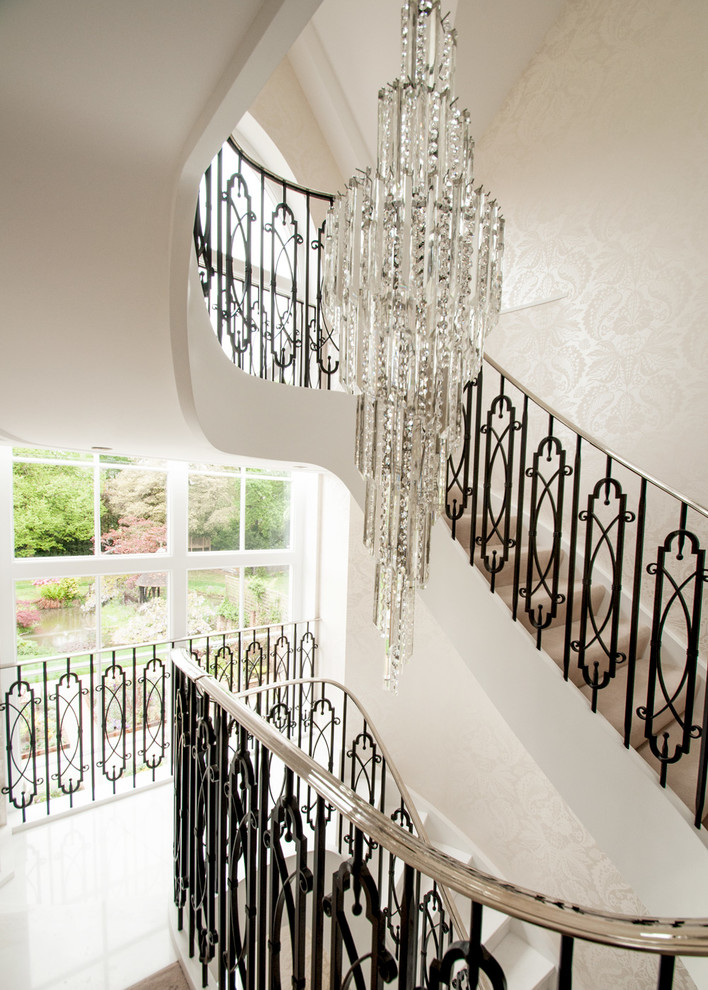 Идея дизайна: большая изогнутая лестница в классическом стиле с мраморными ступенями, подступенками из мрамора и металлическими перилами