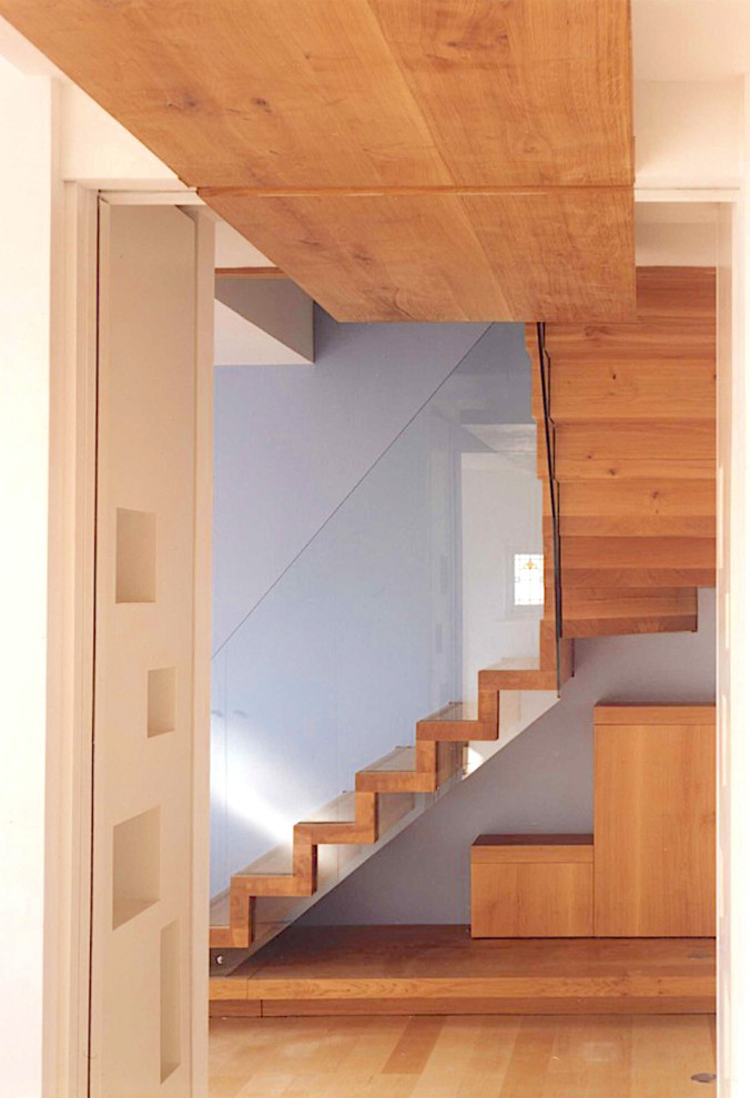 Cette image montre un escalier flottant minimaliste avec des marches en bois et des contremarches en bois.